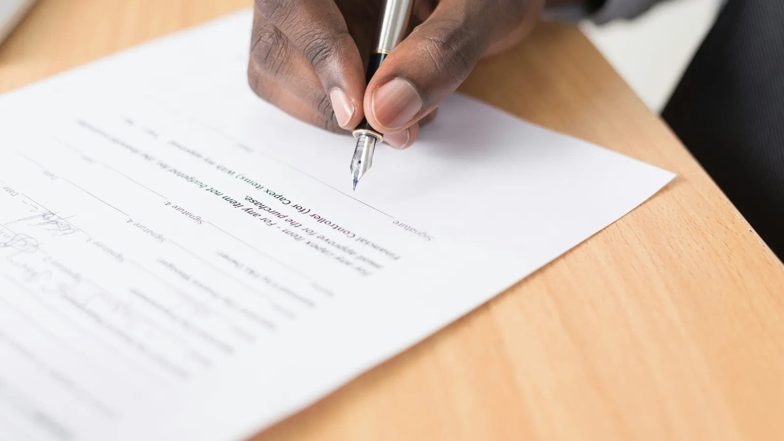 A hand writing on paper, representing credential-cleared liaison interpreting