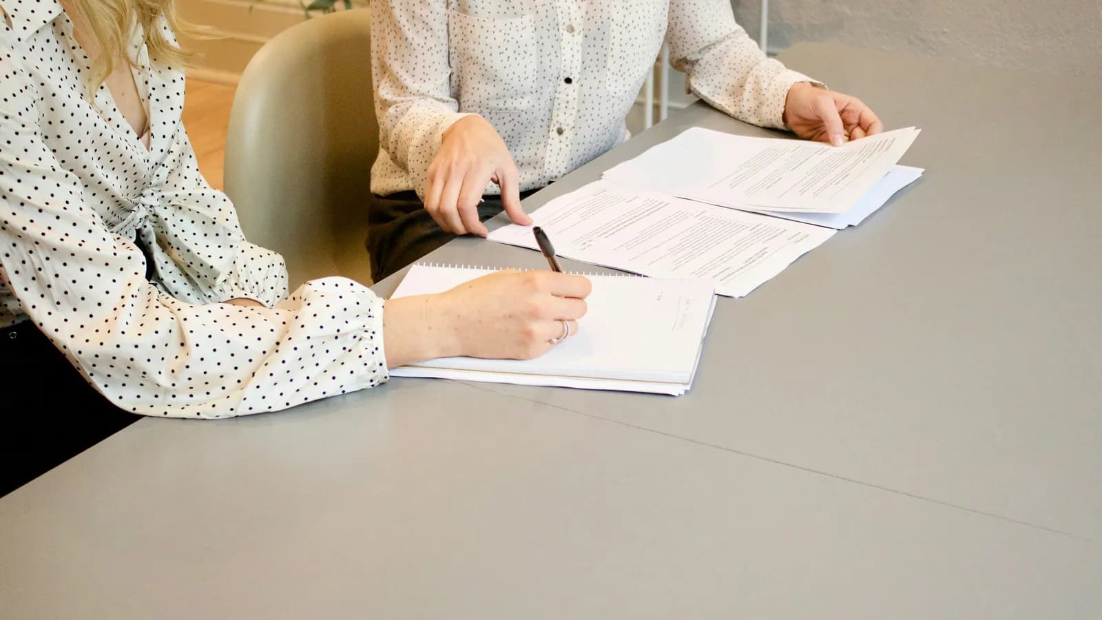 Two people reviewing and signing documents, representing notarial interpreting