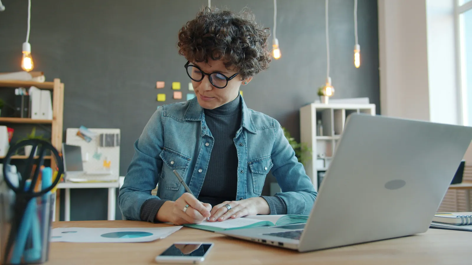 Businesswoman writing in a notebook, representing discreet business interpreting