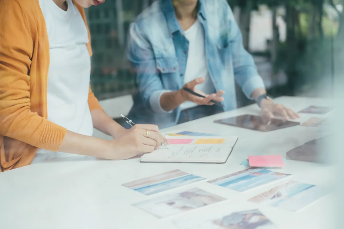 Marketing team reviewing campaign visuals and notes at a shared desk