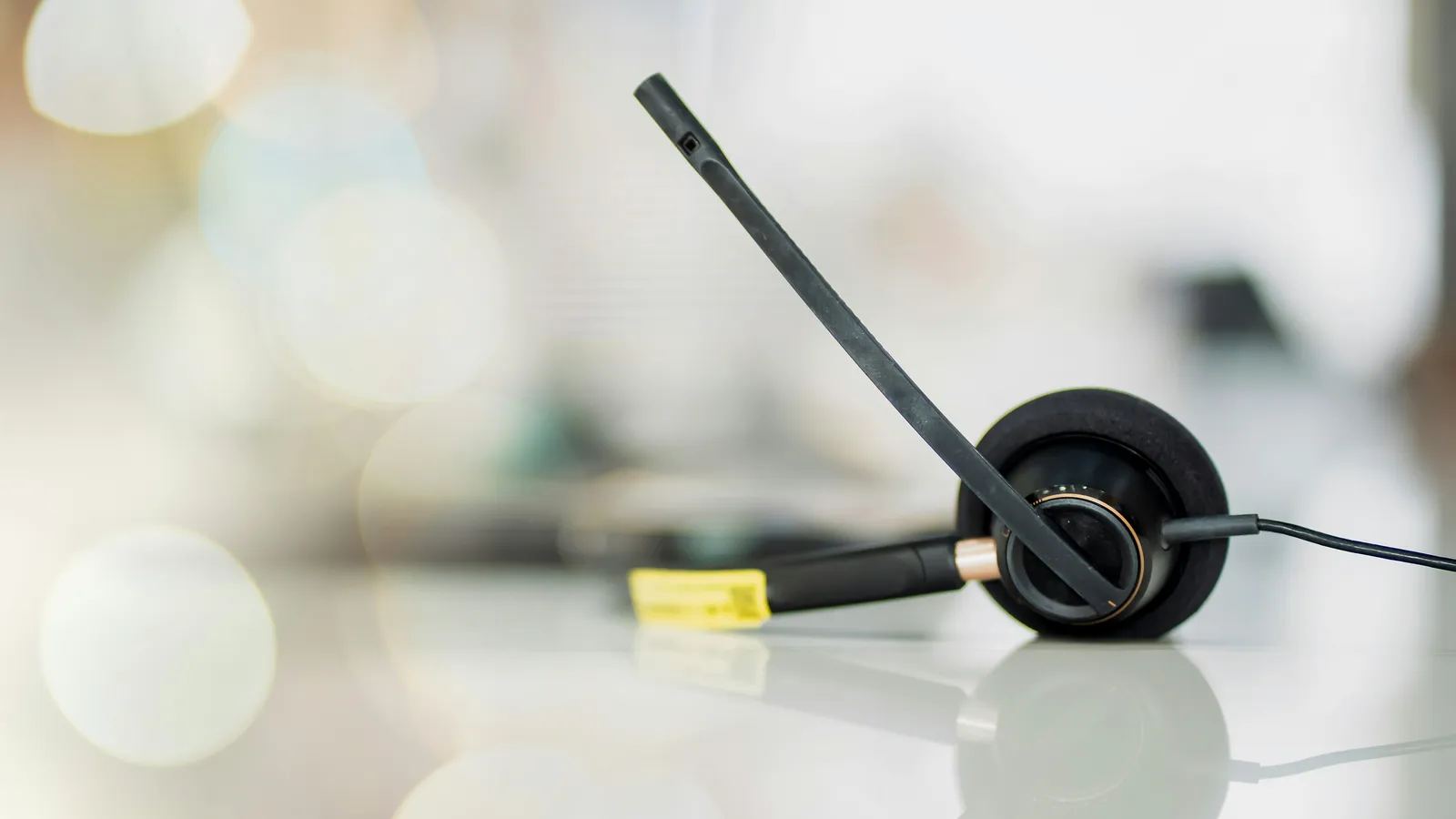 VOIP headset beside a laptop, representing per-minute telephone interpreting