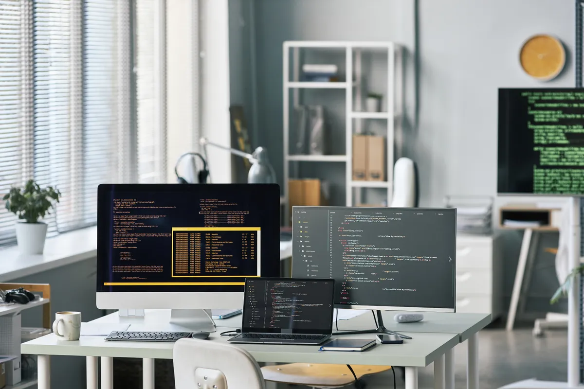 Postazione di sviluppo con diversi schermi di codice sorgente per la localizzazione software