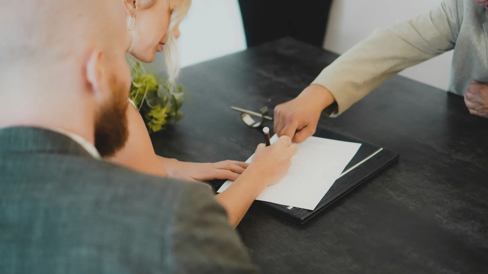 Business partners signing deal documents at a desk, representing M&A interpreting