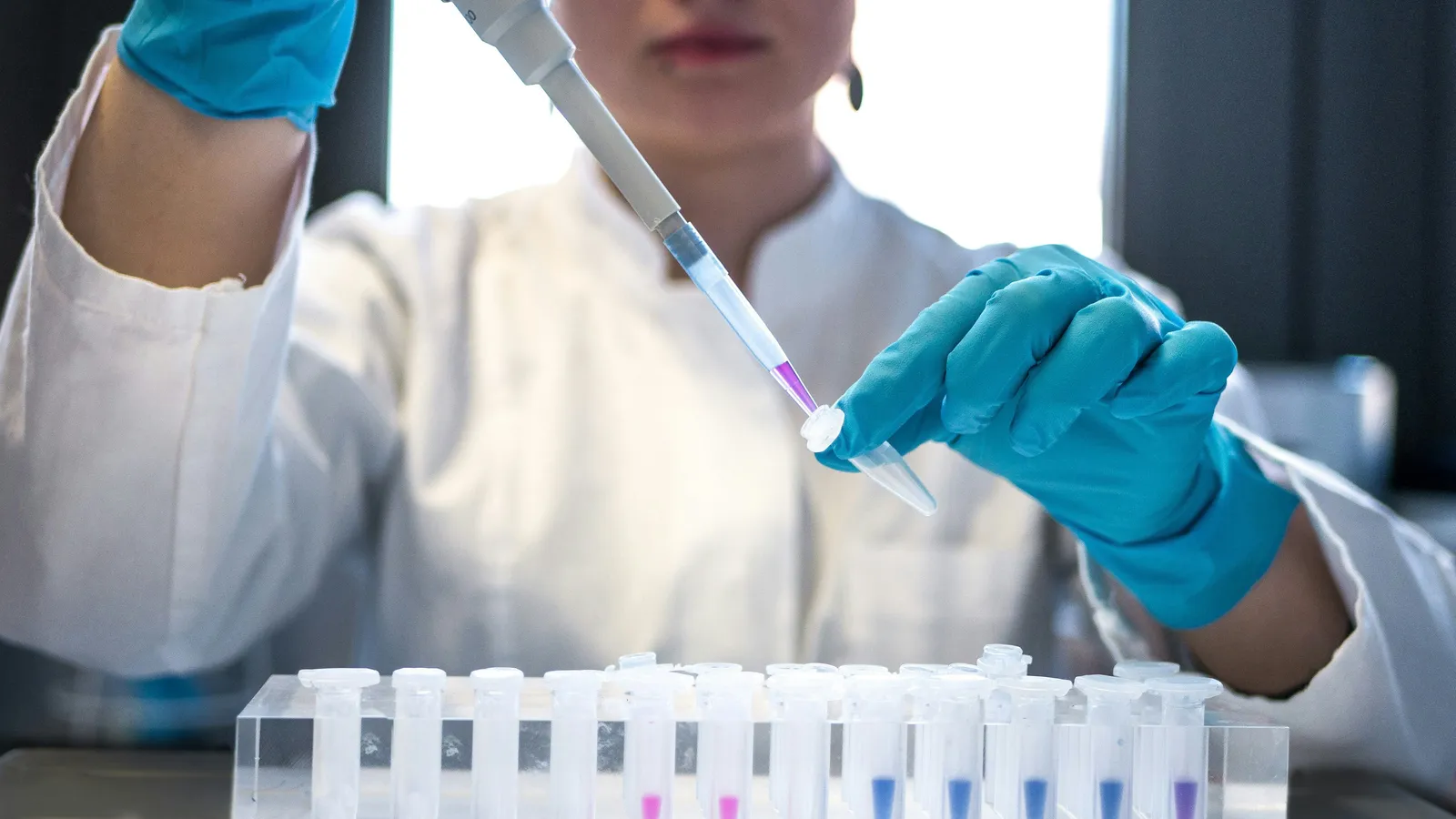 Scientist pipetting in a pharmaceutical laboratory, representing PMDA regulatory interpreting