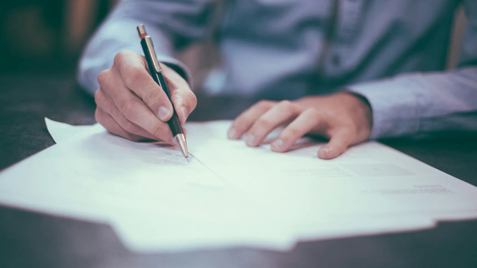 A hand signing a document, representing notarial interpreting