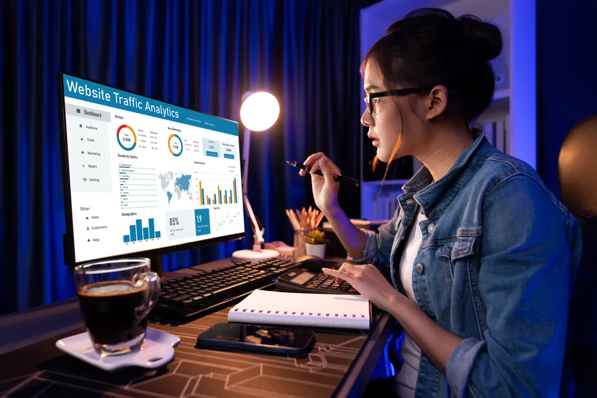 Marketer reviewing a website traffic analytics dashboard on a large monitor