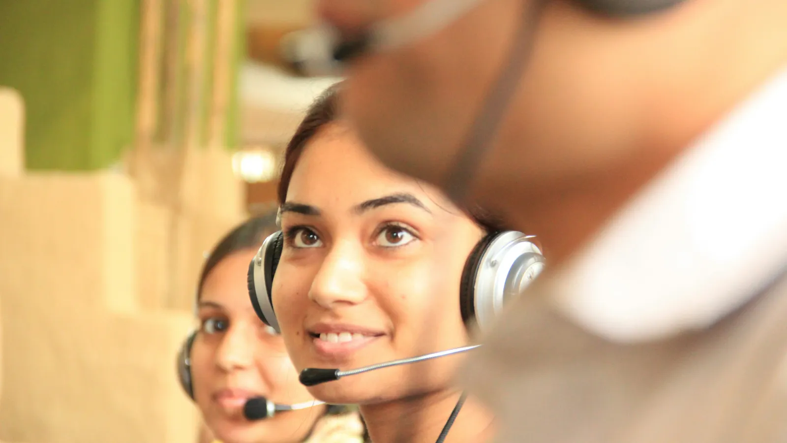Two colleagues wearing headsets, representing paired conference interpreters