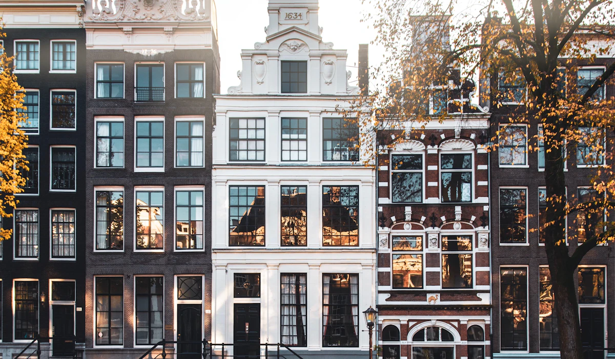 Narrow gabled canal houses reflected in the water in Amsterdam