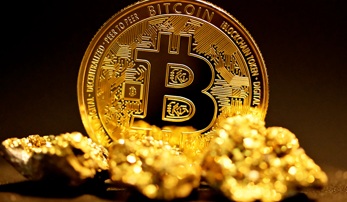 A gold bitcoin coin resting among raw gold nuggets
