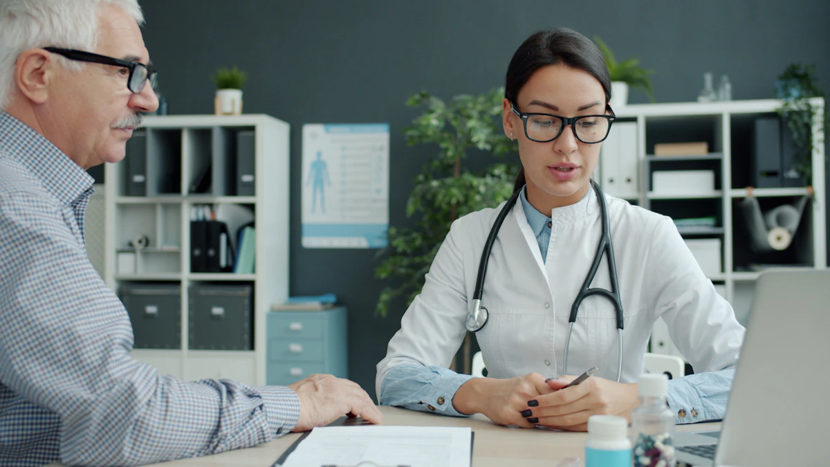A clinician in conversation with an older patient at a consulting-room desk