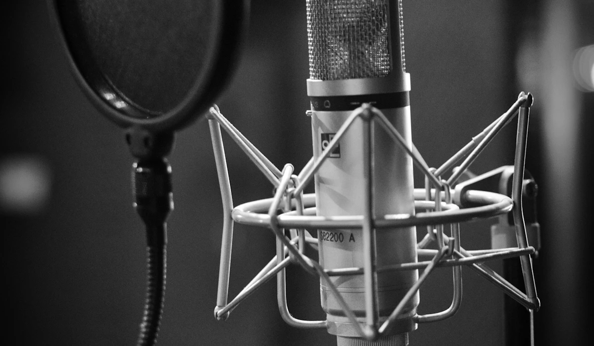 A condenser microphone in a shock mount with a pop filter in a recording studio