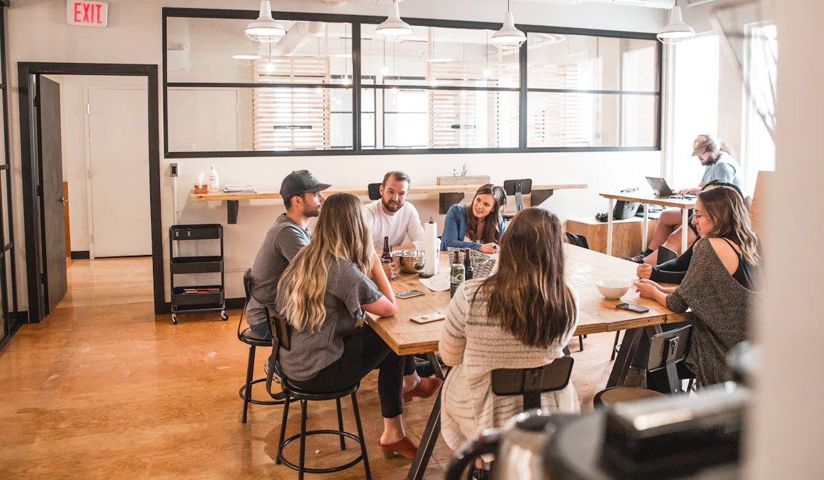 Colleagues talking together around a table in an office