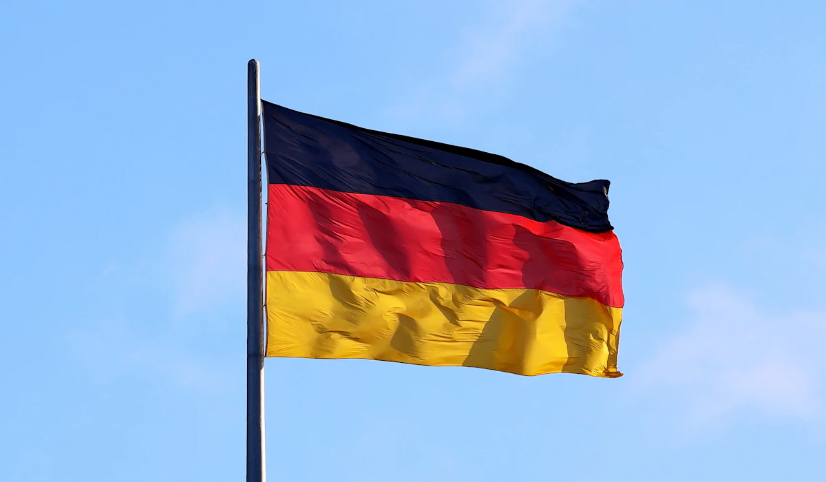 The German flag waving against a clear blue sky