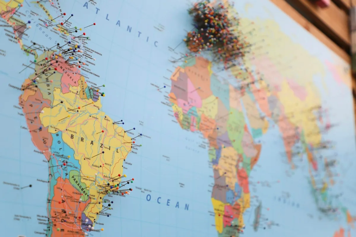 A pinboard world map with pins clustered in Europe and the Americas