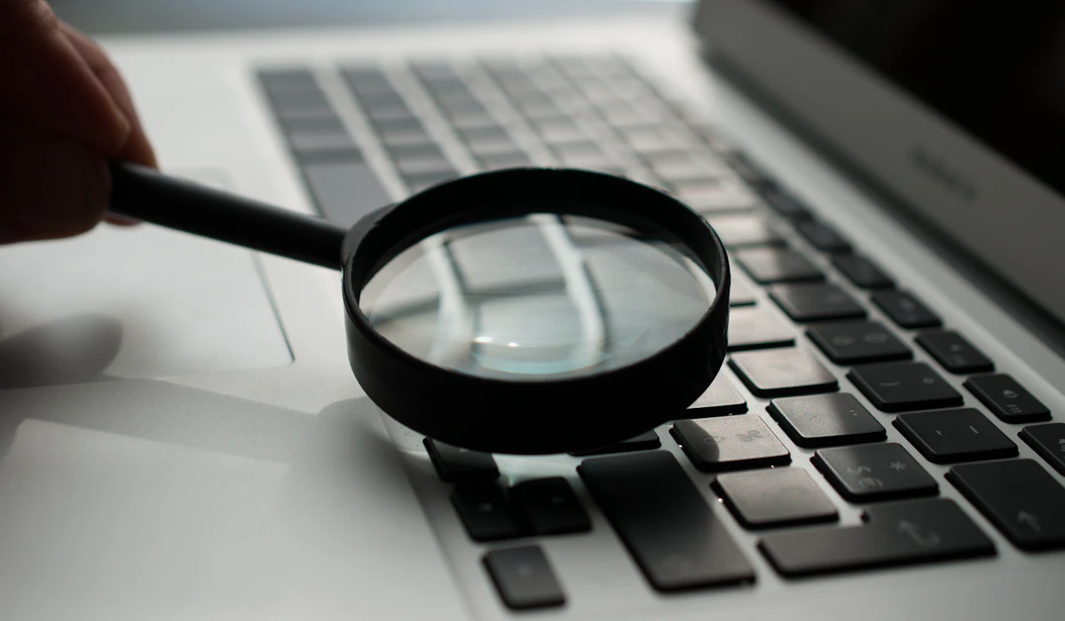 A magnifying glass held over a laptop keyboard