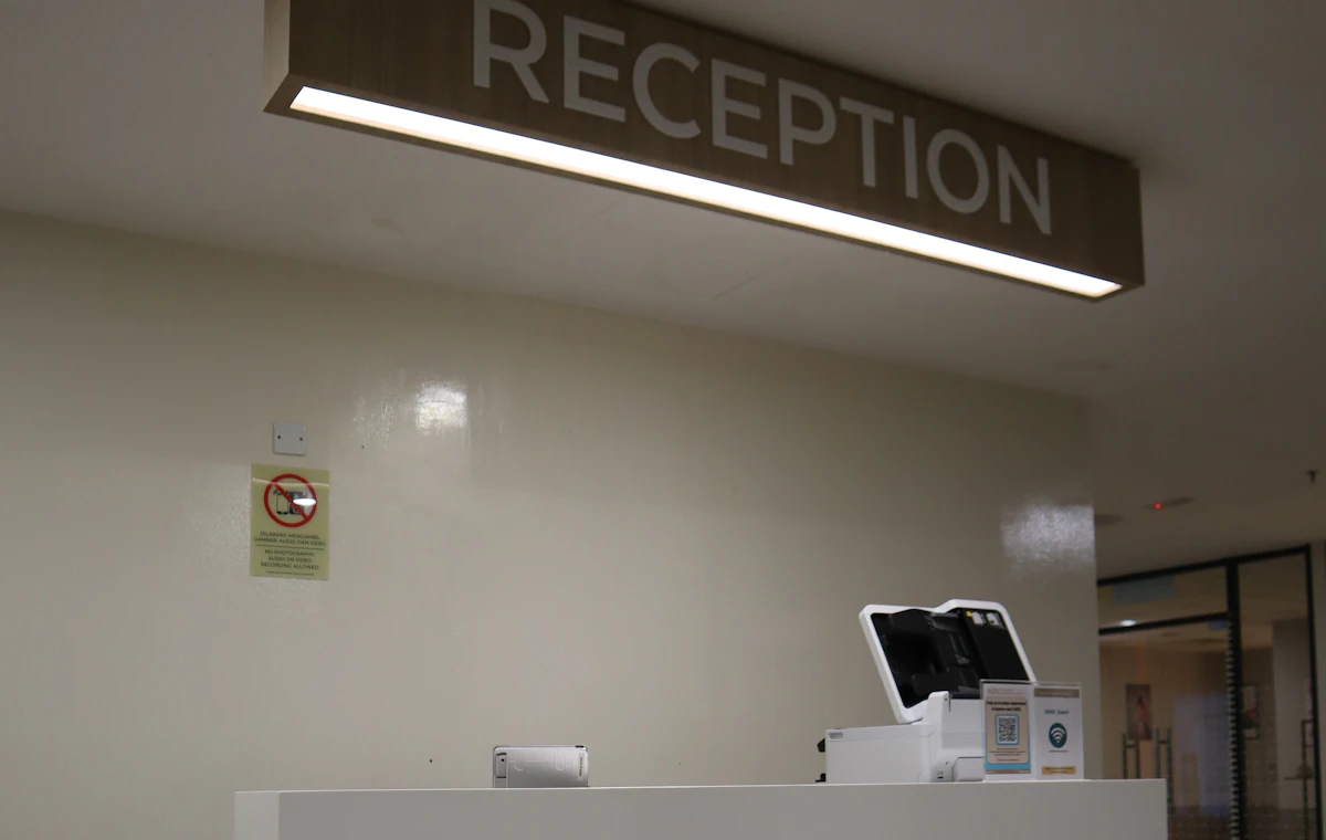 A reception desk beneath an illuminated English-only