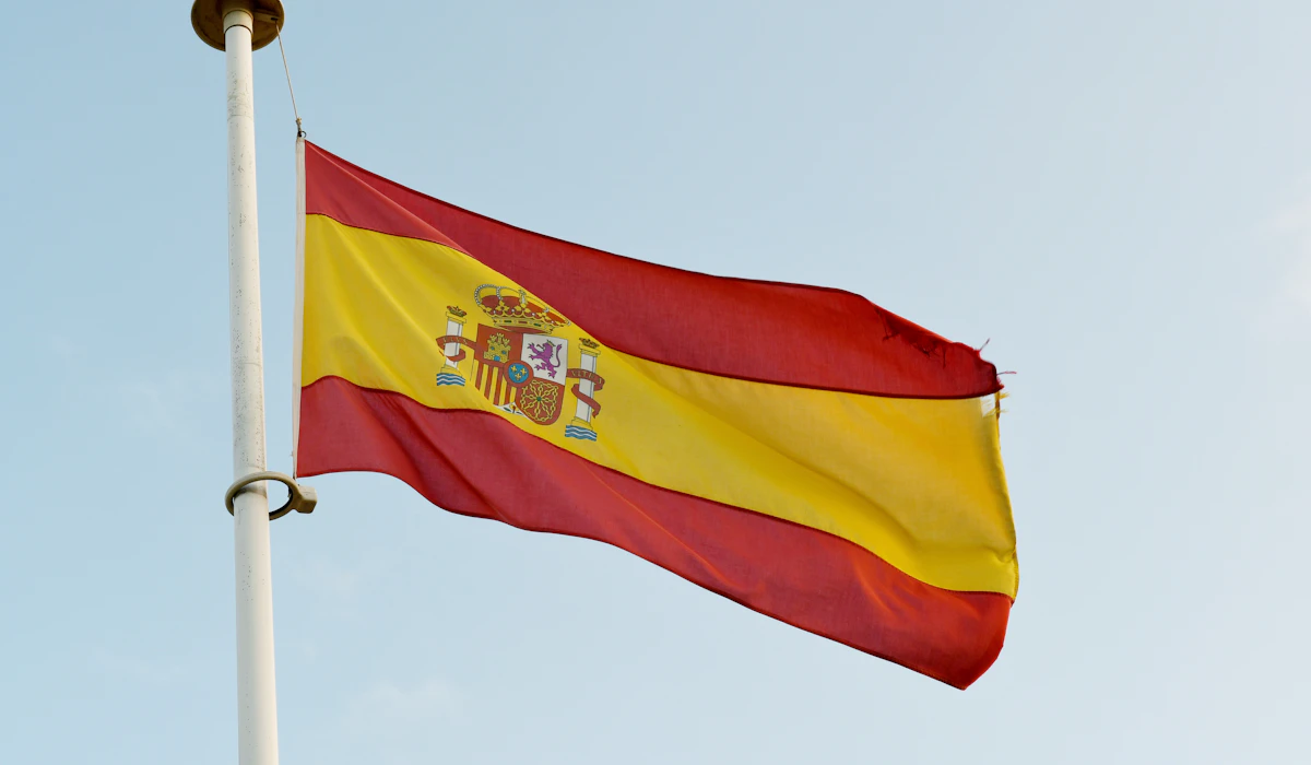 The Spanish flag waving against a clear blue sky