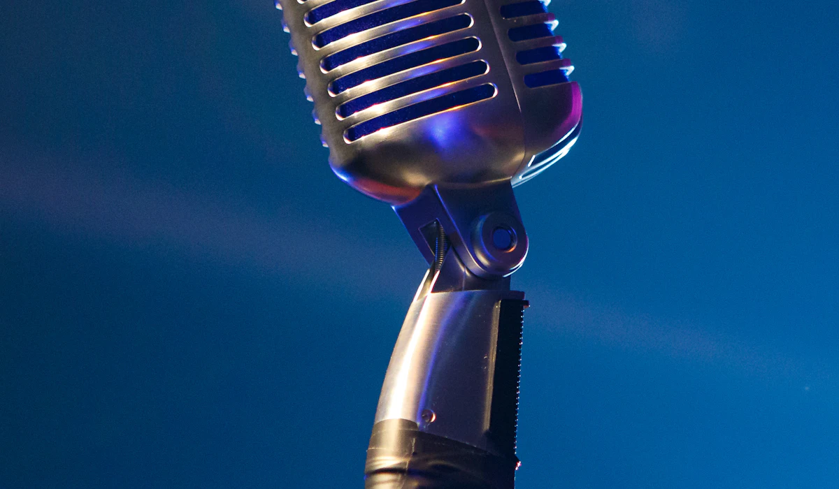 A vintage-style microphone on a stand against a blue background